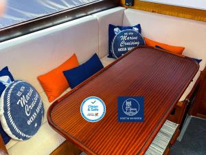un banco con almohadas y una mesa en un barco en Stay in a Yacht - Algarve en Albufeira