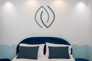 - un lit avec une tête de lit bleue et un panneau au-dessus dans l'établissement Sorrento nature & spa, à Sorrente