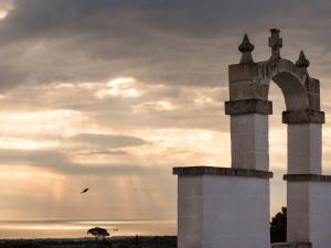 a bird flying in front of a building with an arch at Borgobianco Resort & Spa Polignano - MGallery Collection in Polignano a Mare