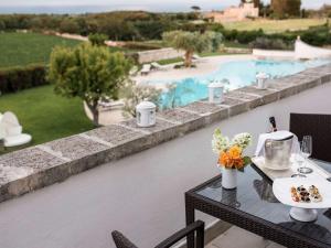 a table with food on it next to a pool at Borgobianco Resort & Spa Polignano - MGallery Collection in Polignano a Mare