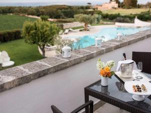 a table with food on it next to a pool at Borgobianco Resort & Spa – MGallery Hotel Collection in Polignano a Mare