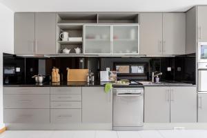 uma cozinha branca com armários e electrodomésticos brancos em ALTIDO Sleek House w/Balcony & 2 Terraces in Porto em Maia