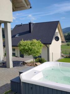 a hot tub in front of a house at Villove Domy Spa in Rajcza