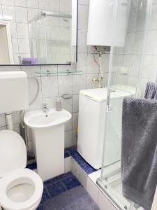 Cosy Apartment on an amazing location! في إسكوبية: حمام ابيض مع مرحاض ومغسلة