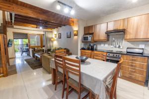 una cucina e un soggiorno con tavolo e sedie di Legend Safaris 257B - in Kruger Park Lodge a Hazyview
