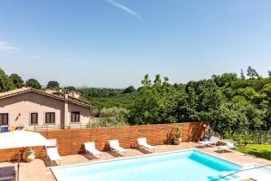 einen Pool mit Stühlen und ein Haus in der Unterkunft Villa Vacanze La Quercia in Carbognano