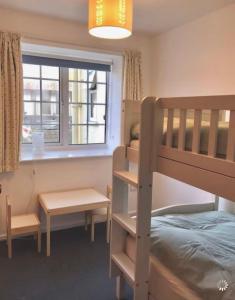 Un dormitorio con una litera y una ventana. en Great price, lovely comfy flat.2 mins from the sea, en Lyme Regis