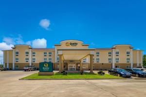 un gran edificio con coches estacionados en un estacionamiento en Quality Inn & Suites en Ardmore