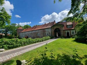 an old stone building with a grass yard at Ferienhaus Hilgenhuus in Hilgenriedersiel
