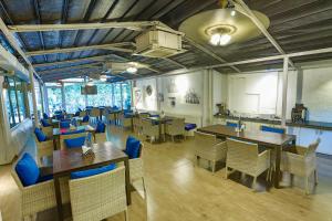 a restaurant with wooden tables and blue chairs at Zone Connect by The Park Calangute in Goa Velha