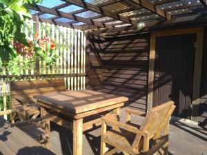 a wooden pergola with a wooden table and chairs on a deck at Pie Andra Pitragā in Pitragutsiyeme