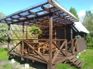 a wooden pavilion with a picnic table in a garden at Pie Andra Pitragā in Pitragutsiyeme