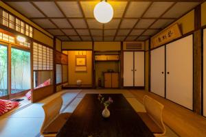 a dining room with a table and chairs in a room at The Machiya Kamiumeya in Kyoto +27 photos