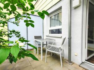 un patio con 2 sillas y una mesa en Gemütliche Ferienwohnung in ruhiger Lage en Dresden