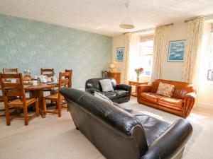 a living room with a leather couch and a table at The Maiflour Bakery in Crickhowell