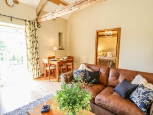 a living room with a brown leather couch and a table at Golwg Las in Llanwrda