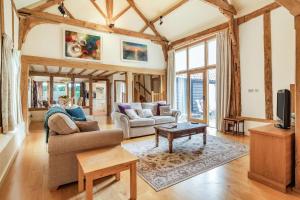 a living room with a couch and a table at Ducksfoot Barn in Pulham Saint Mary Magdalene