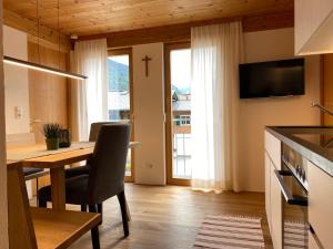 a kitchen with a dining room table with a cross on the wall at Haus Emma in Schoppernau