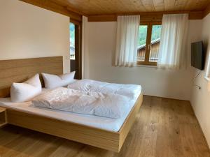 sypialnia z łóżkiem z białą pościelą i oknem w obiekcie Haus Emma w mieście Schoppernau