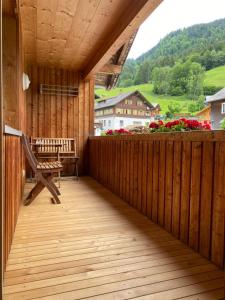 a wooden balcony with a bench and a table at Haus Emma in Schoppernau