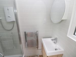 ein weißes Badezimmer mit Waschbecken und Dusche in der Unterkunft Saltwater in Haverfordwest + 9 Fotos