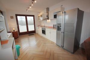 Una cocina con refrigerador de acero inoxidable y pisos de madera. en Haus am Kurpark Wohnung 7, en Büsum