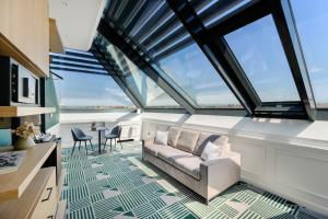 a living room with a couch and some windows at Hotel Oktogon Haggenmacher by Continental Group in Budapest