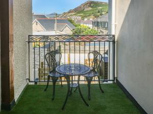 a table and two chairs on a balcony at Gwenallt in Pwllheli