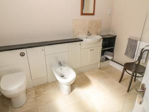 a bathroom with a toilet and a sink at 7 Cummertrees in Annan