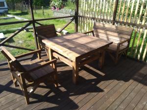 a wooden table and two chairs on a deck at Pie Andra Pitragā in Pitragutsiyeme