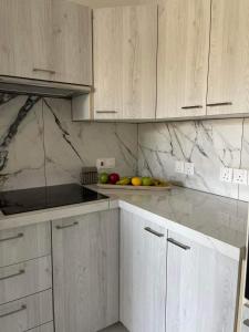 a kitchen with white cabinets and a plate of fruit at Oneiro Napa Suite in Ayia Napa