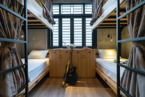 a room with two bunk beds and a guitar in it at 9 Hostel and Bar in Ho Chi Minh City