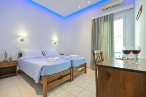 a bedroom with a bed and two glasses of wine at Hotel Zeus in Naxos Chora