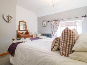 a bedroom with a white bed with a clock on the wall at The Cottage in Lincoln