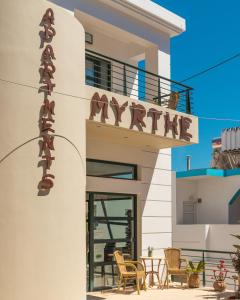 a building with a sign that reads mine at Myrthe Apartments in Myrtos