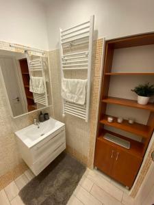 ミシュコルツにあるChill Apartmanの白い洗面台と鏡のあるバスルーム