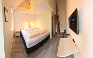 a bedroom with a bed and a flat screen tv at GEG Hotel in Landskrona