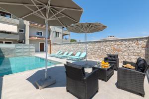 un patio con sillas y sombrillas junto a una piscina en Villa Divina, en Kremasti