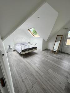 um quarto com uma cama e piso em madeira em Lovely 2 Bedroom Flat with Roof Terrace in London NW6 em Londres