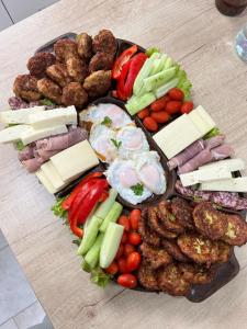 un piatto di alimenti con carne e verdure su un tavolo di Pensiunea ARMONIA a Văleni