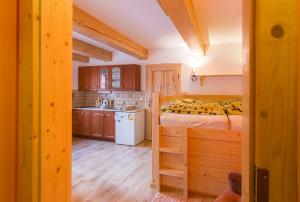 Un dormitorio con una cama y una pequeña cocina. en Apartmán mezi stromy, en Rokytnice nad Jizerou