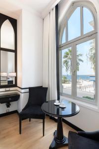 uma sala de estar com uma mesa e vista para a praia em EN Hotel Boutique Izmir em Konak