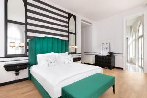 a bedroom with a large white bed with a green headboard at EN Hotel Boutique Izmir in Konak