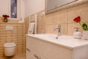 a bathroom with a white sink and a toilet at Summer breeze luxury rooms in Split
