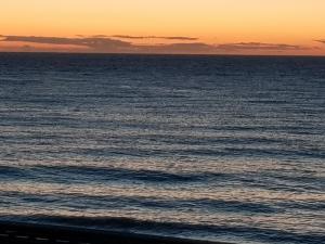 uma imagem do oceano ao pôr-do-sol em vue sur Mer " VILLA DES MOUETTES " les pieds dans l eau em Veulettes-sur-Mer
