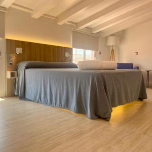 a bedroom with a bed with a blue blanket on it at Hotel Nereida in L'Estartit