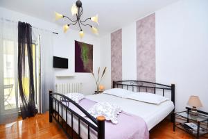 - une chambre avec un lit et un lustre dans l'établissement Artsy Apartment, à Klis