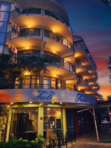 un grand bâtiment avec une façade éclairée la nuit dans l'établissement Hotel Juli, à Sunny Beach