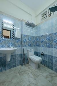 a blue tiled bathroom with a toilet and a sink at Kurinji Wanderlust Resort Munnar in Munnar