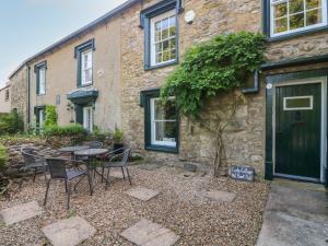 a patio with chairs and a table in front of a building at Curlew Cottage in Carnforth